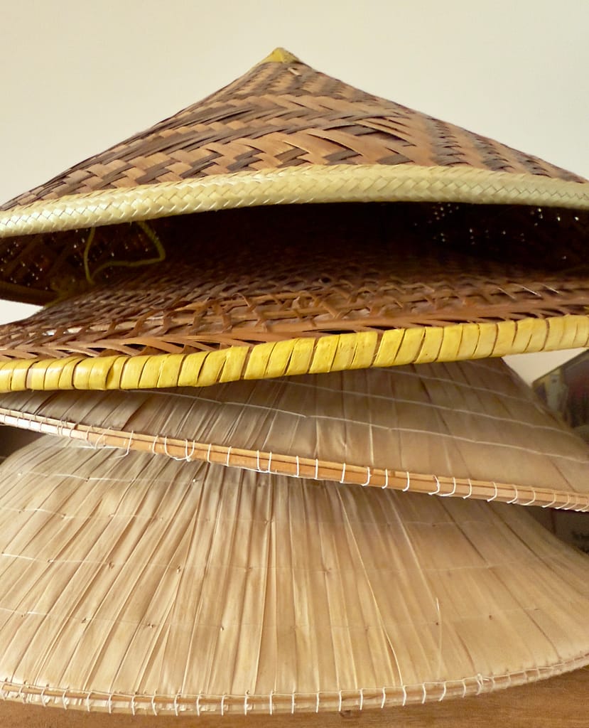 Stack of Vietnamese conical hats showing the many roles Naomi holds and curious how many hats you wear
